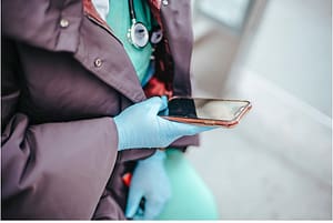 a lady in gloves using a touchscreen phone